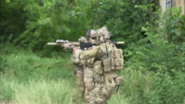 군인들로 이루어진 팀워크 작전중적을 공격하는 보호용 전투복을 군인들 소총을 군인들 — 비디오
