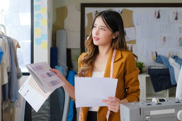 Stock image Female fashion designer woman working on her designs in workshop studio, Female business owner with clothes, Tailoring business owner, Clothing store owner, Design fashion clothes by designer. High