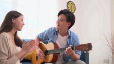 Hafta sonları evde gitar çalan bir çift mutlu insanlar evde eğleniyor ve rahatlıyor iyi ilişkileri olan romantik bir çift. Yüksek kalite 4k görüntü