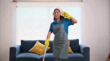 Mutlu bir kadın evi temizliyor, mutlulukla dans ediyor, temizlikçi ve temizlikçi, evde ev işi yapan insanlar. Yüksek kalite 4k görüntü