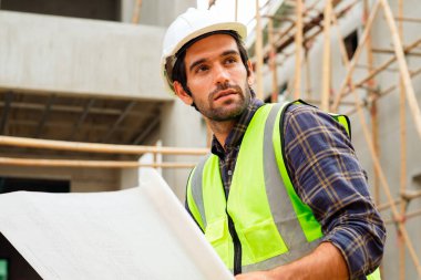 İnşaat şantiyesinde çalışan güvenlik üniformalı inşaat mühendisi portresi inşaat alanında inşaat işçisi kontrol ve kontrol projesi, yeni projede mimarlık mühendisliği. Yüksek