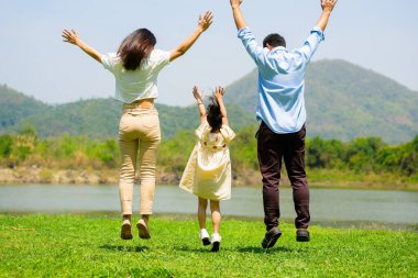 Mutlu bir aile hafta sonu parkta birlikte eğleniyor ve dışarıda oynuyor, neşeli bir aile babası, anne ve çocuğu parkta pikniğin tadını çıkarıyor, aileler kızlarıyla ve oğullarıyla birlikte doğada seyahat ediyor,