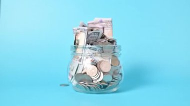 Banknotlar ve madeni paralar küçük cam kavanozlarda para tasarrufu, Amerikan doları, nakit para doları, iş yatırımı ve gelir, küresel mali kriz, para tasarrufu için azalır. Yüksek kalite