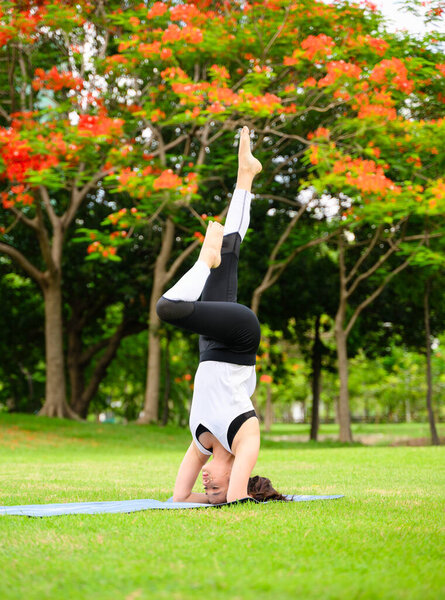 Healthy young woman enjoying and relaxing yoga outdoor in green park, Woman doing yoga exercise outdoor with happiness, Positive fit woman practicing yoga on open air outside in morning