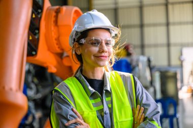 Fabrikada robot makine otomasyonuyla çalışan kadın mühendis endüstride akıllı teknolojili kadın teknisyen, robot makinenin parçalarını kontrol eden ve kontrol eden kadın işçi.