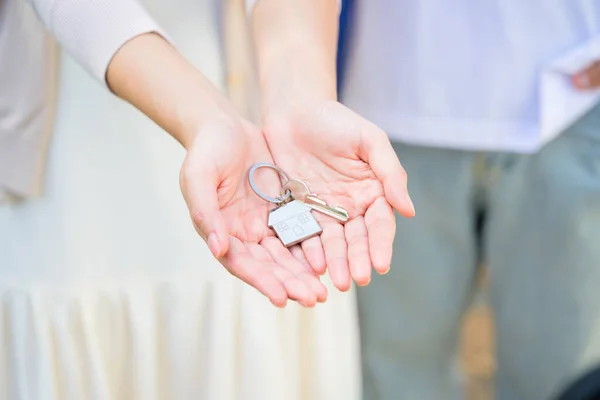 Couple of husband and wife holding key of new house, People spending time together in home, New life with new home, Happy people celebrating in new house, First time real estate owners. High quality