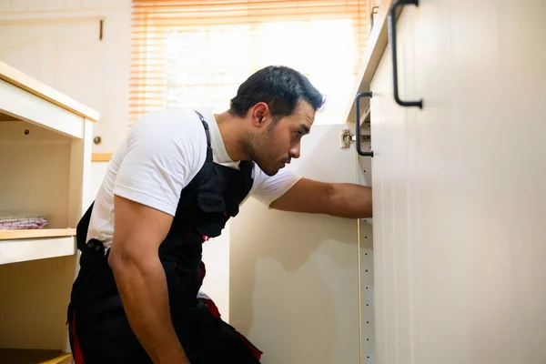 Siyah Tulumlu Tamirci Mutfaktaki Dolabı Onarıyor Teknisyen Fırını Mutfak Bakım — Stok fotoğraf