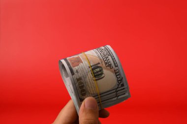 Kırmızı arka planda 100 dolarlık banknotlar, para biriktirmek için banknotlar, nakit para dolarları, iş yatırımları ve gelir, küresel mali kriz, kazanç ve tasarruf konsepti. Yüksek