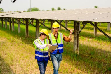 Güneş pili çiftliğindeki güneş panellerini kontrol eden ve koruyan bakım mühendisleri, ekolojik güneş çiftliğinde çalışan teknisyenler, temiz enerji teknolojisi olan insanlar, güneş enerjisi santrali