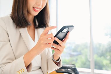 Akıllı telefondan arkadaşlarıyla sohbet eden mutlu bir kadın ofisteki cep telefonunu kullanan bir iş kadını sosyal medyayla rahatlayan bir kadın memur ve insan teknolojisi. Yüksek kalite fotoğraf.