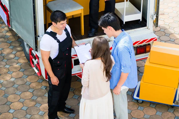 stock image Man and woman accepting and holding delivery parcel boxes from deliveryman at home, Delivery service at home. High quality photo