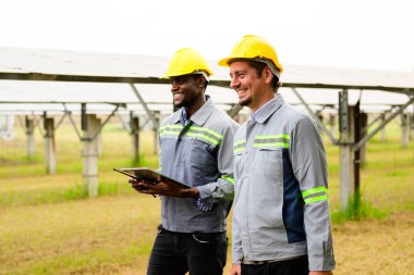 Güneş pili çiftliğindeki güneş panellerini kontrol eden ve koruyan bakım mühendisleri, ekolojik güneş çiftliğinde çalışan teknisyenler, temiz enerji teknolojisi olan insanlar, yenilenebilir enerji