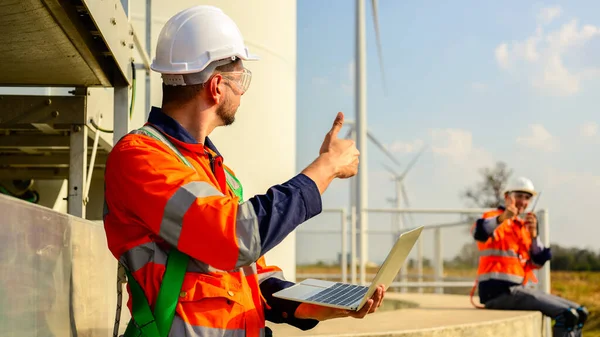 Professional engineers technicians team working with teamwork at wind turbine farm field, Environmental engineer researching and developing clean energy sources, Turbine industrial farm