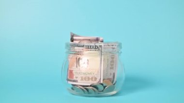Banknotlar ve madeni paralar küçük cam kavanozdaki para artışı, Amerikan doları, nakit para doları, iş yatırımı ve gelir, küresel ekonomik kriz, para biriktiren insanlar. Yüksek kalite