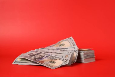 Kırmızı arka planda yüz dolarlık banknotlar, para tasarrufu için banknotlar, nakit para dolarları, iş yatırımları ve gelir, küresel mali kriz, kazanç ve tasarruf para konsepti. Yüksek kalite fotoğraf