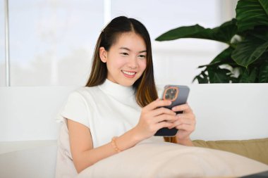 Bir kadın çeşitli günlük aktiviteler için akıllı bir telefon kullanıyor. Fotoğraf çok kaliteli.