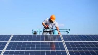 Güneş pili çiftliğine güneş panelleri kuran profesyonel teknisyen, elektrik santralinde çalışan mühendis, güneş panelleri alanında elektrik sistemi bakımı, çevre dostu ve temiz enerji