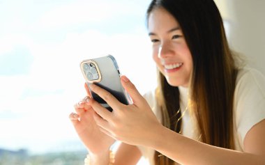 Bir kadın çeşitli günlük aktiviteler için akıllı bir telefon kullanıyor. Fotoğraf çok kaliteli.