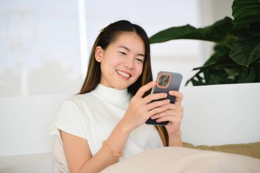 Bir kadın çeşitli günlük aktiviteler için akıllı bir telefon kullanıyor. Fotoğraf çok kaliteli.