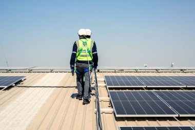 Güneş enerjisi tarlasında güvenlik kaskı olan profesyonel mühendisler, enerji fabrikasının çatısında güneş pili olan teknisyenler, sürdürülebilir kaynak kavramı