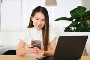 Bir kadın çeşitli günlük aktiviteler için akıllı bir telefon kullanıyor. Fotoğraf çok kaliteli.