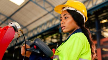 Technician engineer checking and repairing automatic robotic machine at industrial factory, Worker working at production line machine system in factory