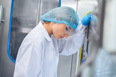 Şişeleme fabrikası işçisi sevkiyattan önce su şişelerinin kalitesini kontrol ediyor. Bitkide kullanılan ters osmoz sistemi. Su saflığı ve şişeleme sürecinde kalite kontrolü. Yüksek kalite fotoğraf.