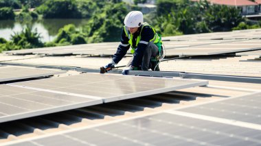 Güneş enerjisi tarlasında güvenlik kaskı olan profesyonel mühendisler, enerji fabrikasının çatısında güneş pili olan teknisyenler, sürdürülebilir kaynak kavramı