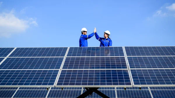 Technicians workers team installing solar panels at industrial solar cell farm, Engineers working at power station, Electric system maintenance at solar panels field, Eco friendly and clean energy