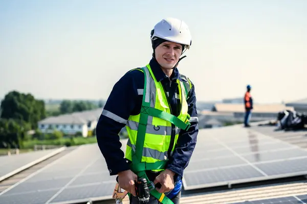 Professional engineers with safety helmet checking solar system at solar power farm, Technicians with solar cell on roof of power factory, Concept of sustainable resources