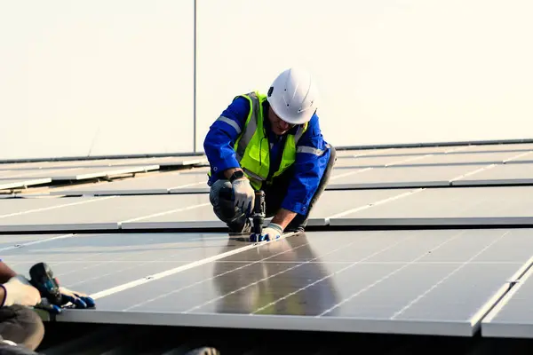 Güneş pili çiftliğine güneş panelleri kuran bakım teknisyenleri, elektrik santralinde çalışan mühendisler, güneş panelleri alanında elektrik sistemi bakımı, çevre dostu ve temiz enerji