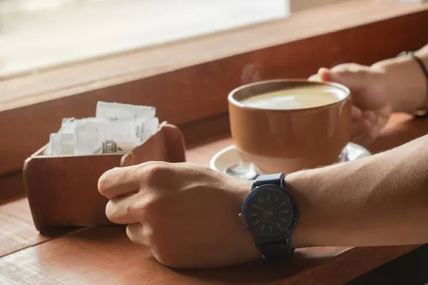 stock image Close-up of a man holding a brown cup of hot coffee to drink.