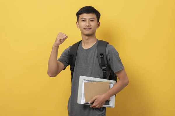 Sırt Çantası Kitaplarıyla Gülümseyen Genç Üniversite Öğrencisi Sarı Arka Planda — Stok fotoğraf