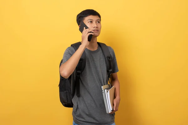 Sırt Çantalı Kitaplı Gülümseyen Genç Bir Üniversite Öğrencisi Telefonda Konuşuyor — Stok fotoğraf
