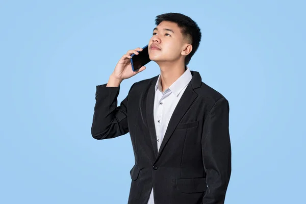 Fiatal Jóképű Ázsiai Üzletember Mosolyog Segítségével Okostelefon Kezében Elszigetelt Kék — Stock Fotó
