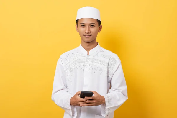 Junge Hübsche Asiatische Muslimische Mann Lächelt Mit Smartphone Vor Orangefarbenem — Stockfoto