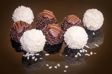 Luxurious mixed handmade chocolate praline. Variety of coconut, vanilla and lemon truffles. Pralines designed in Belgium and arranged on dark background. Assortment sweet confectionery.