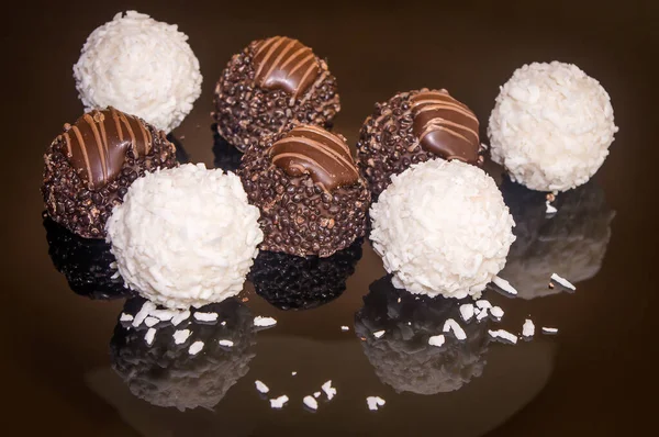 Luxurious handmade chocolate praline. Variety of coconut, vanilla and lemon truffles. Pralines designed in Belgium and arranged on a dark background.