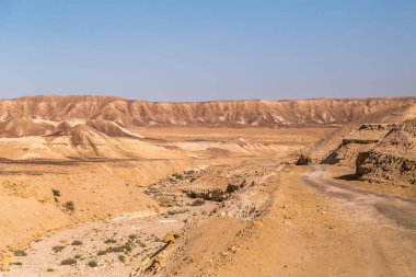 İsrail 'deki Rocky Dağları Midbar Yehuda' daki kurak Yahudi Çölü boyunca çakıllı ve asfaltsız yolun yanında. Küçük Krater 'den Otoyol 90' a ve Golan Yolu 'na. Negev Çölü 'nün manzarası.
