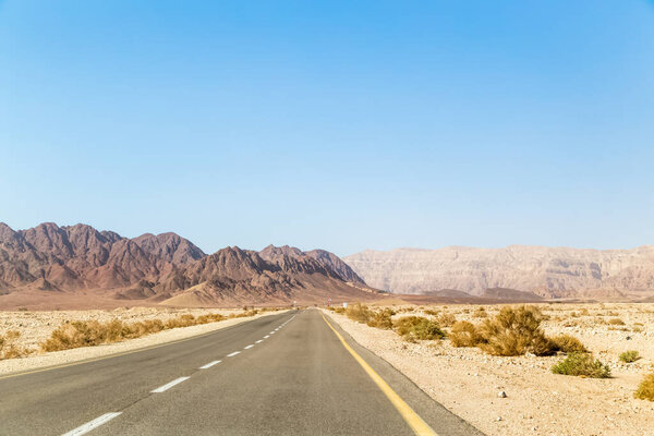 Road in desert with blue sky. Paved road leading up to the mountains Timna open empty road. Timna National Park.