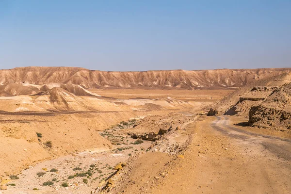 İsrail 'deki Rocky Dağları Midbar Yehuda' daki kurak Yahudi Çölü boyunca çakıllı ve asfaltsız yolun yanında. Küçük Krater 'den Otoyol 90' a ve Golan Yolu 'na. Negev Çölü 'nün manzarası.