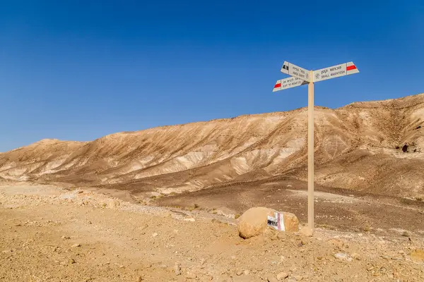 Golan patikalarındaki işaretler. Yürüyüş işaretleri, yürüyüş yolları, yol işaretleri, Negev çöl yollarındaki ok işaretleri. Turist işaretli doğa. İsrail 'deki Negev çölünde mavi gökyüzü olan bir işaret direği..