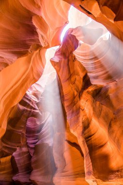 Kuzey Arizona 'daki Navajo Rezervasyon Sayfası' ndaki Yukarı Antilop Kanyonu 'nda ışık huzmeleri. Kaya oluşumu. Direk güneş ışınları deliklerden aşağıya doğru yayılıyor. Meşhur ve en çok fotoğraflanmış slot kanyonu. Yürüyüşçüler için popüler yerler.