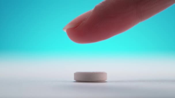 Šumivá Tableta Tlačena Prstem Vlevo Čistém Bílém Stole Modrém Pozadí — Stock video