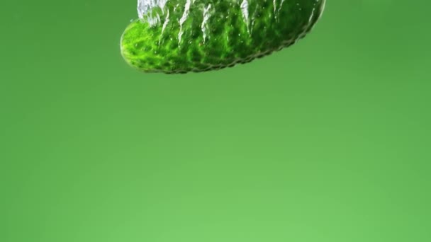 绿色背景下的黄瓜落水并在慢动作中产生气泡 — 图库视频影像