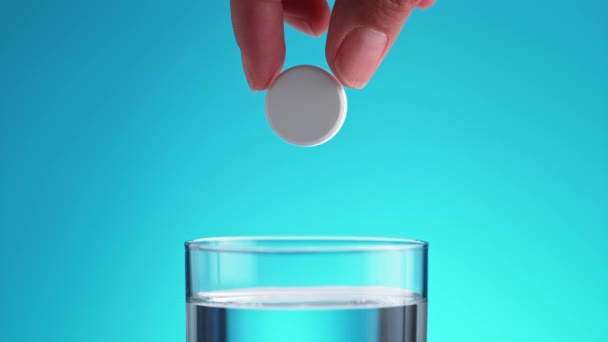 青い背景にスローモーションで指と滝から純粋な水のガラスに発売されます — ストック動画