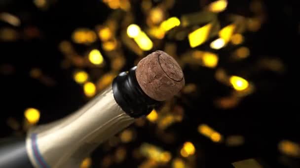 Cork Popping Champagne Bottle Golden Confetti Black Background — стокове відео