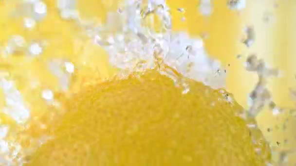 在黄色背景下缓慢运动的柠檬果肉水花 — 图库视频影像