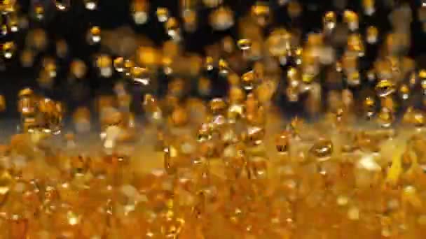 慢动作中的金色威士忌飞溅 抽象喷涂琥珀液体在黑色背景下产生水滴和飞溅 — 图库视频影像