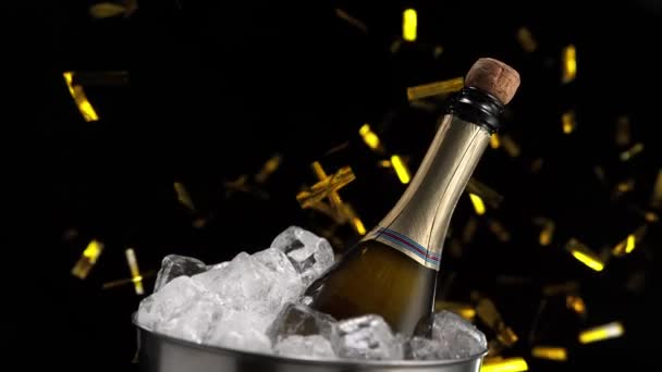 瓶塞从香槟酒瓶中弹出 在一篮子冰块中冷却 背景是五彩纸屑 — 图库视频影像